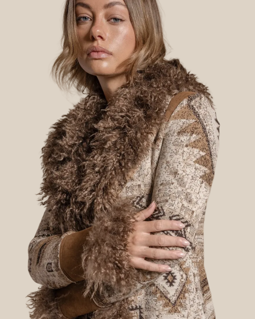 Woman wearing a patterned coat with a fur-lined hood against a beige background