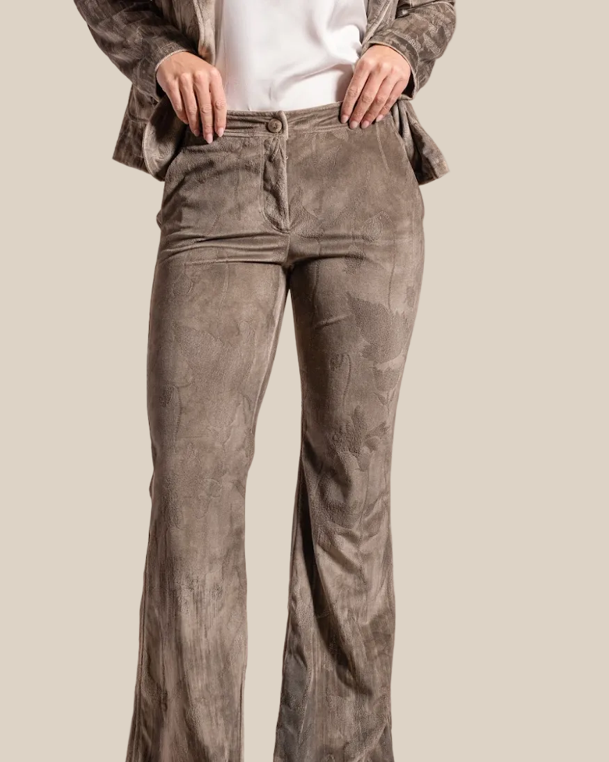 Person wearing brown corduroy pants on a beige background