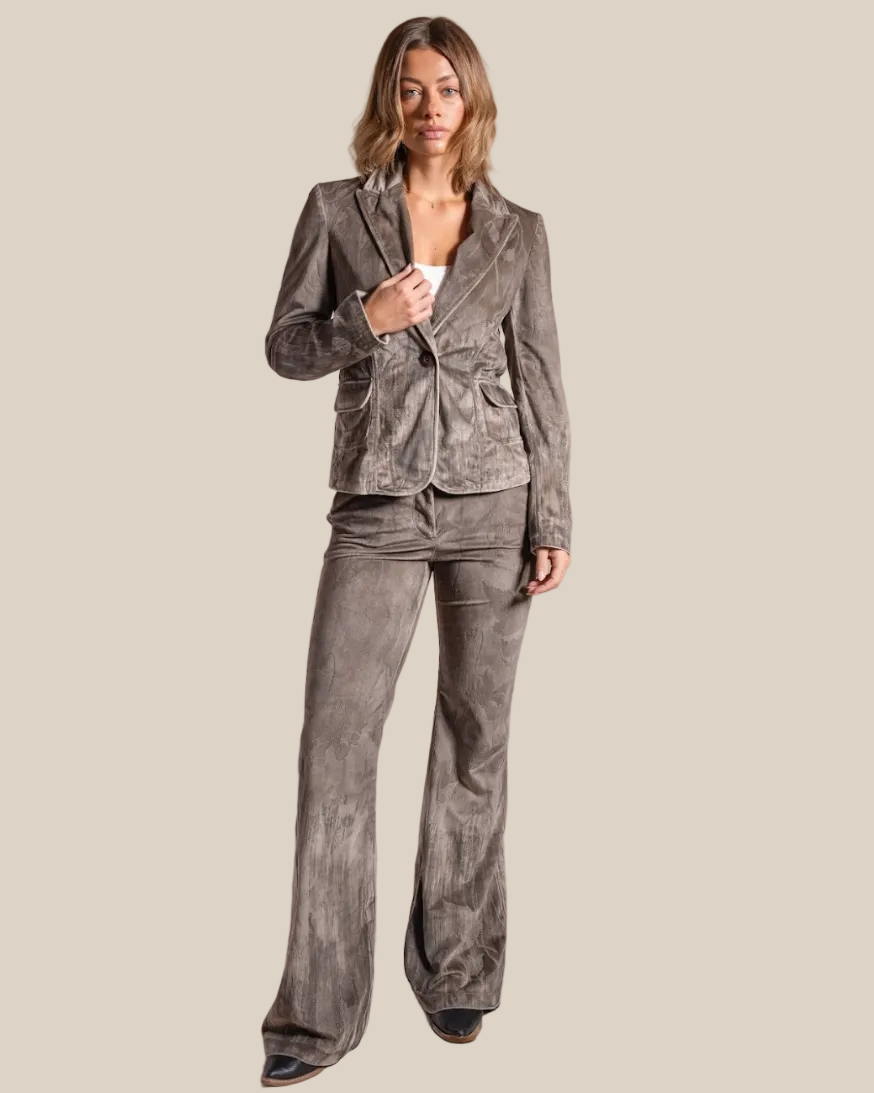 Woman wearing a gray corduroy suit on a beige background