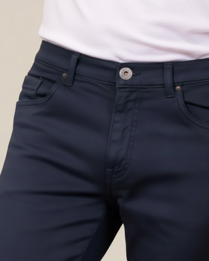 Navy pants worn by a person on a beige background