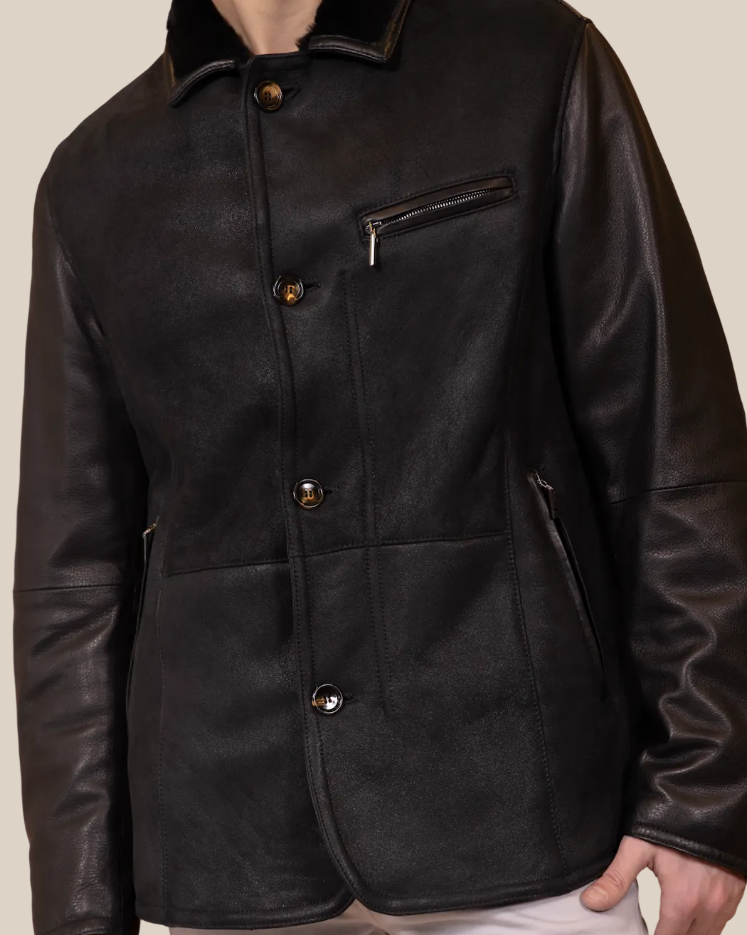 Black leather jacket with white pants on a brown background