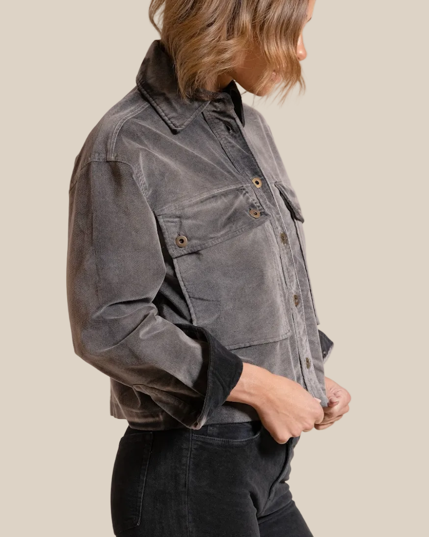 Person wearing a gray jacket on a beige background