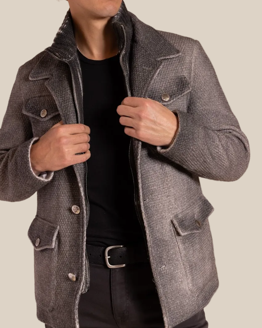Man wearing a gray coat against a beige background