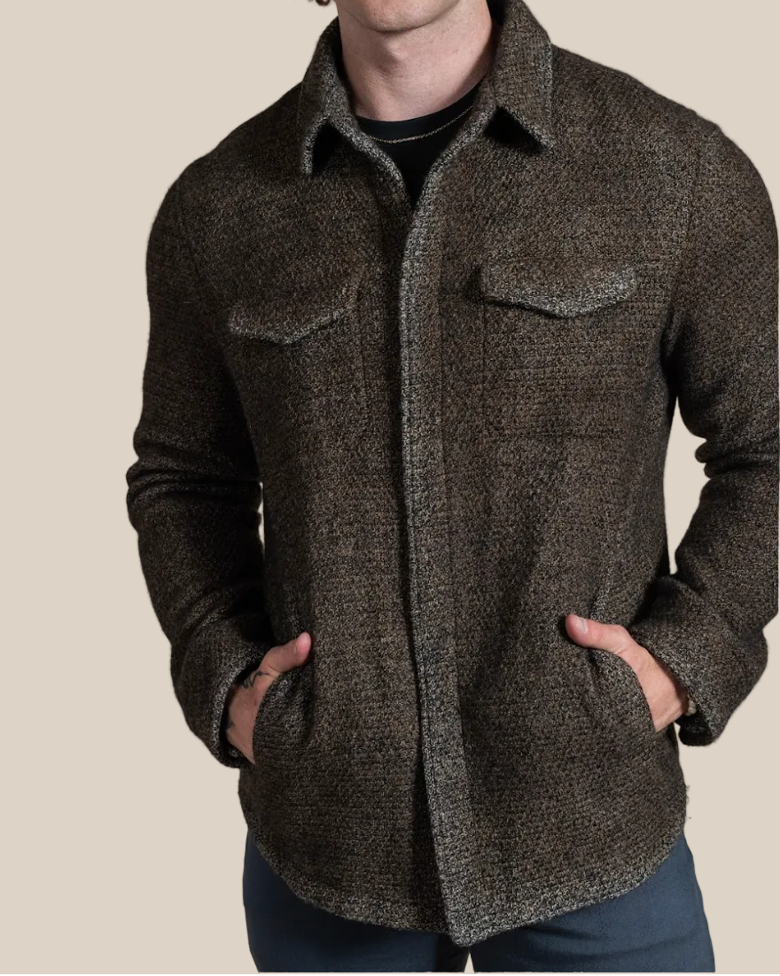 Man wearing a brown textured jacket against a beige background