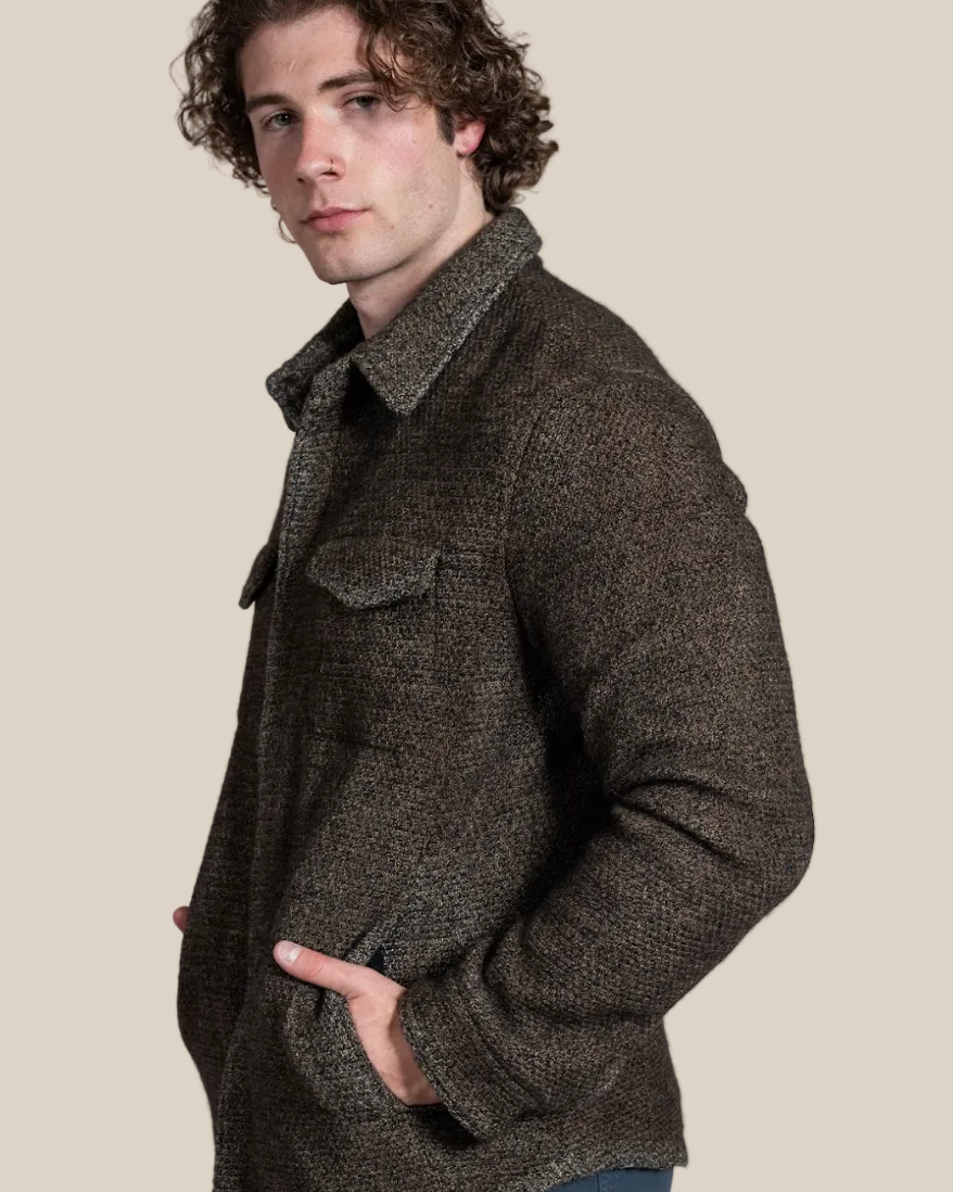Man wearing a brown textured jacket against a beige background