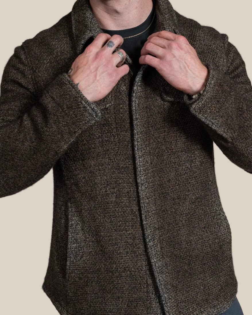 Man wearing a brown textured jacket against a beige background