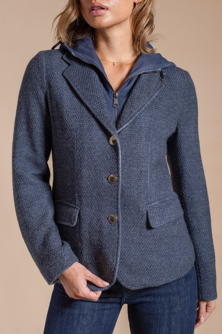 Blue textured jacket worn by a person on a beige background