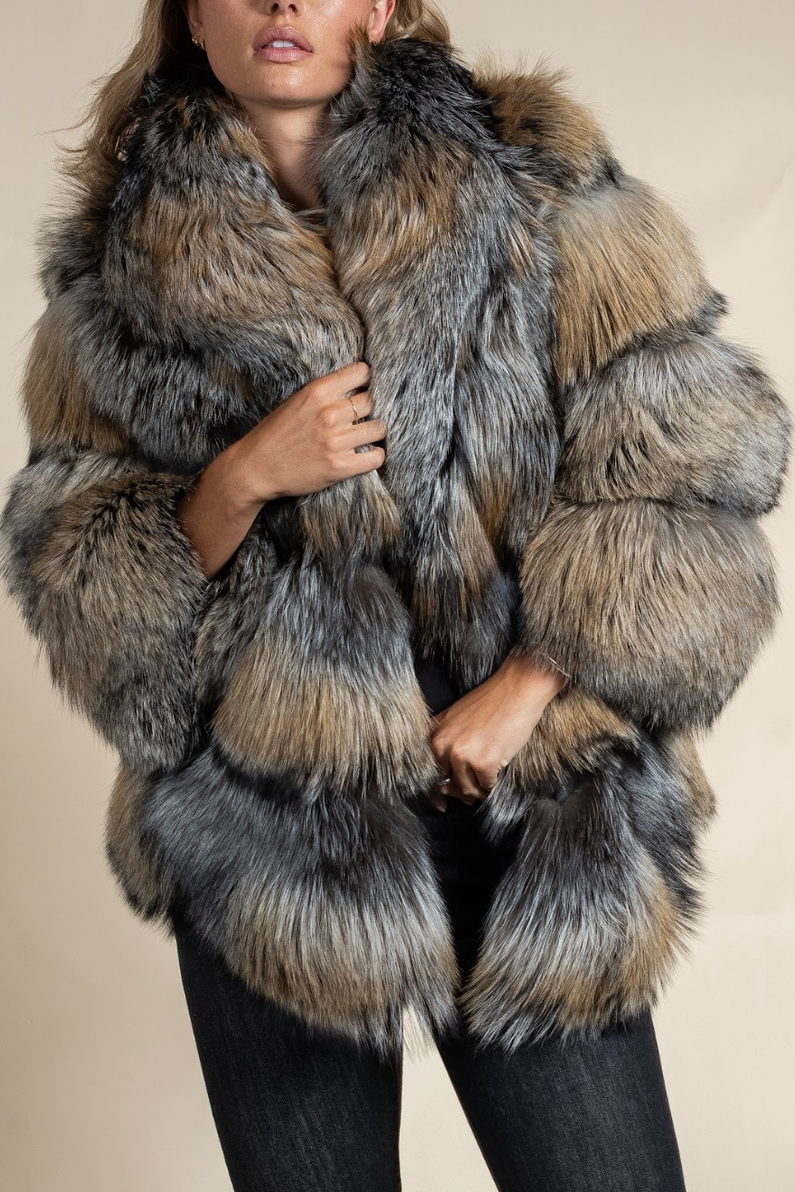 Person wearing a fur coat with a neutral background