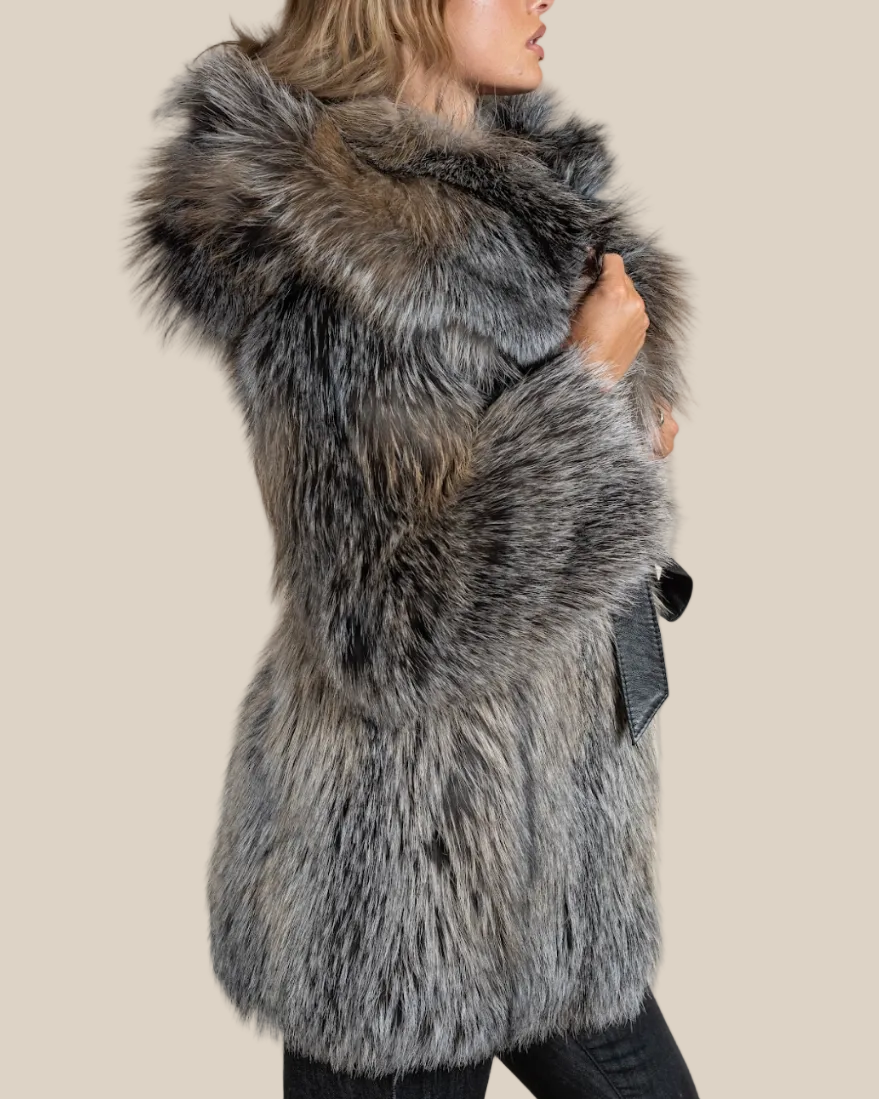 Person wearing a gray fur vest on a beige background