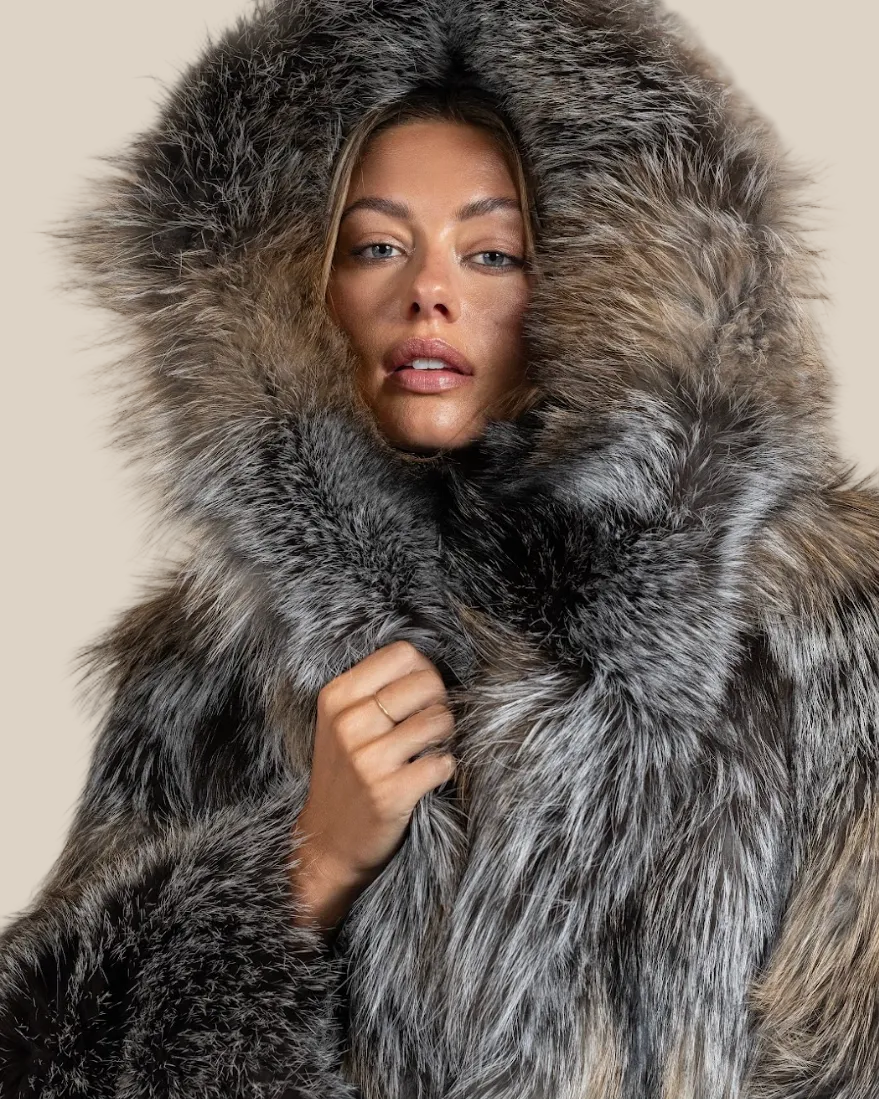Person wearing a fur coat with a hood against a neutral background