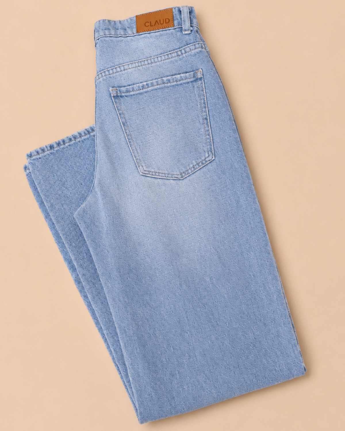 Light blue jeans with a brand label on a beige background