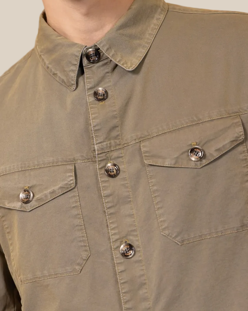 Close-up of a person wearing a green jacket with button details on a beige background