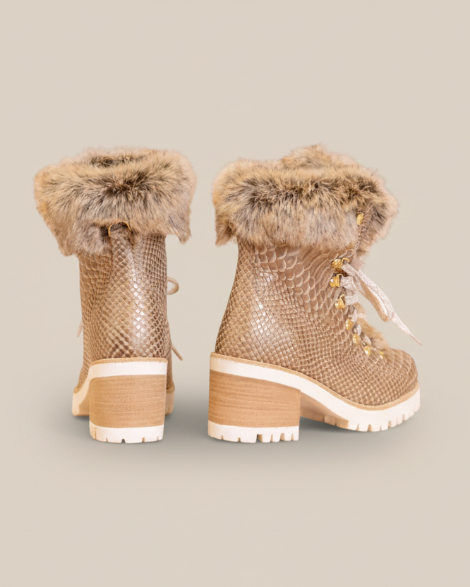 Pair of beige winter boots with fur trim on a white background