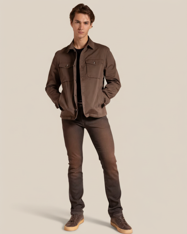 Man wearing a brown jacket and dark jeans against a beige background
