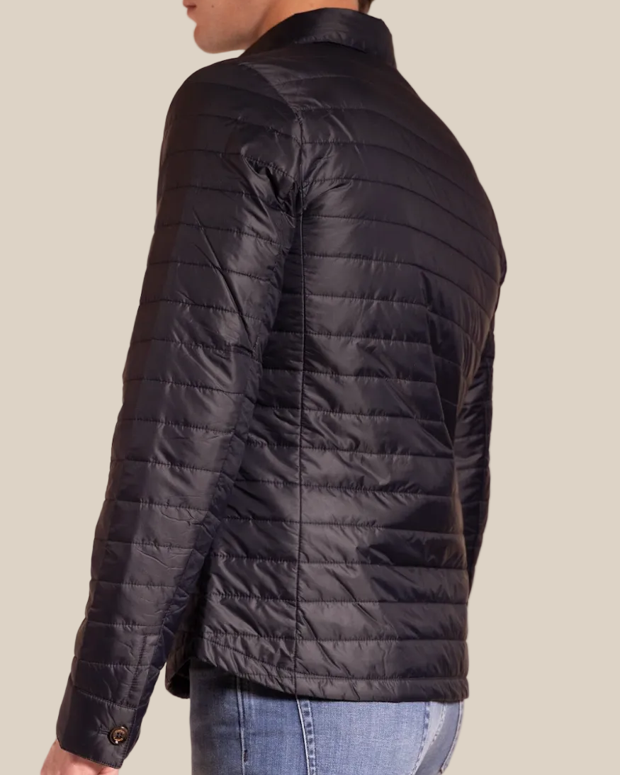 Man wearing a black quilted jacket on a beige background