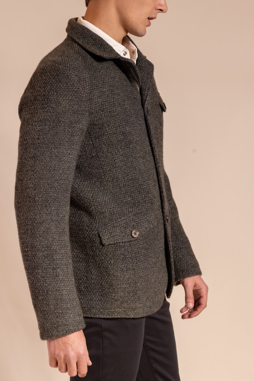 Man wearing a textured brown coat on a beige background