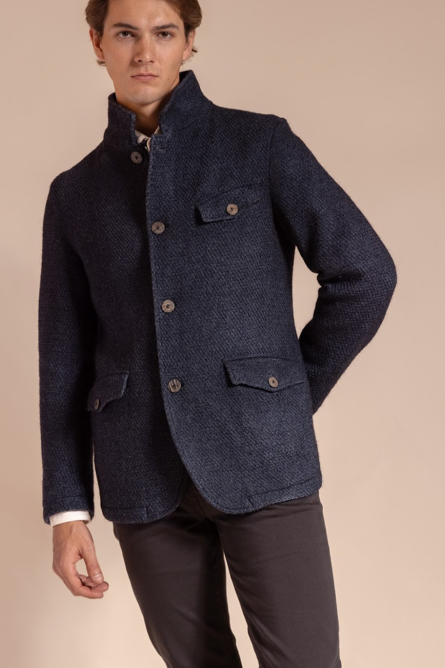 Man wearing a dark blue jacket on a beige background