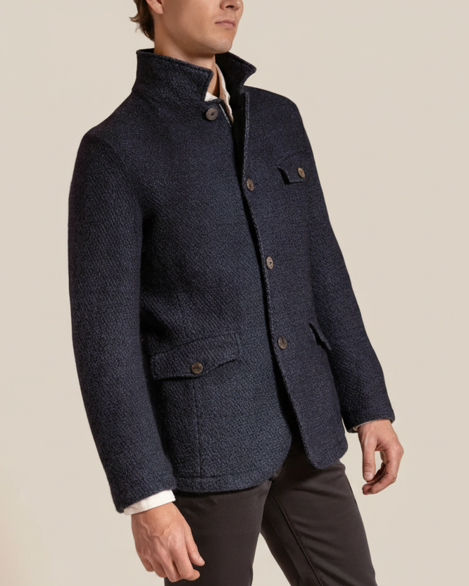 Man wearing a navy blue textured jacket on a beige background