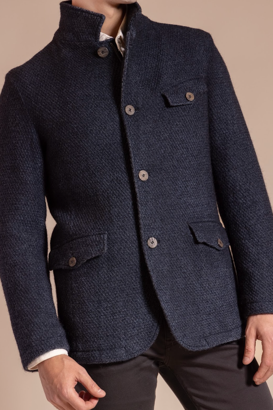 Navy blazer with button details on a beige background