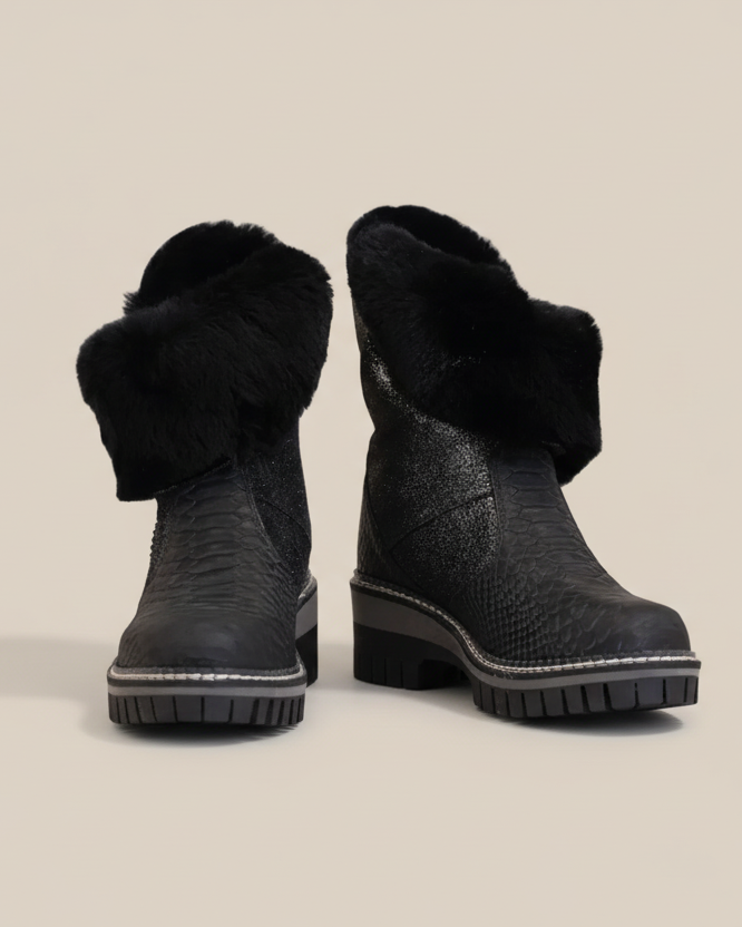 Pair of black winter boots with fur trim on a white background