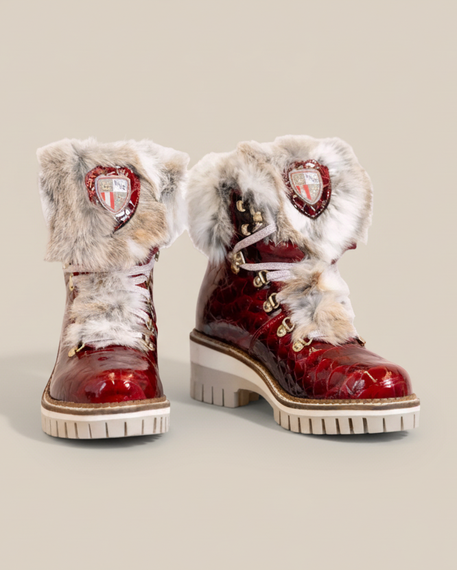 Red winter boots with fur trim on a white background