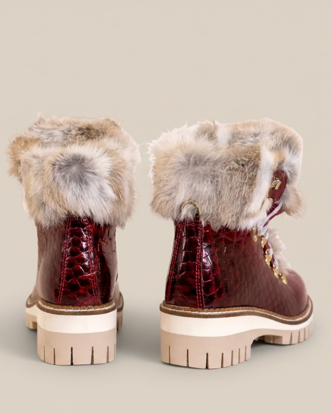 Pair of brown boots with fur trim on a white background