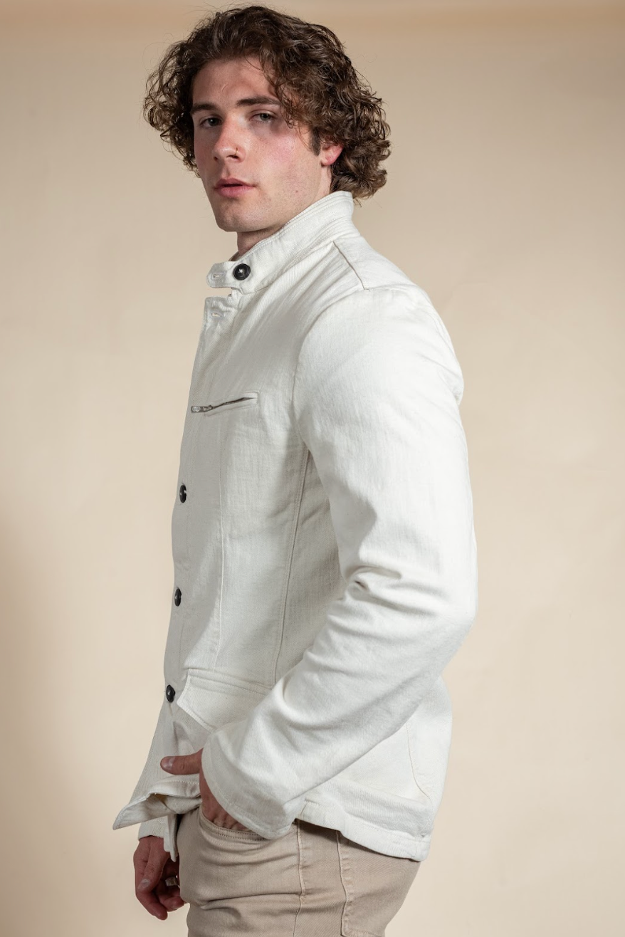 Man wearing a white jacket against a beige background