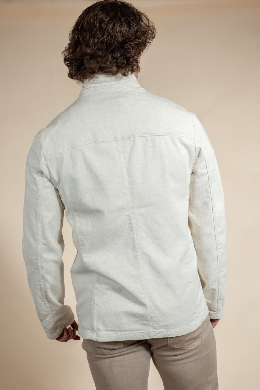 Person wearing a light-colored jacket on a beige background