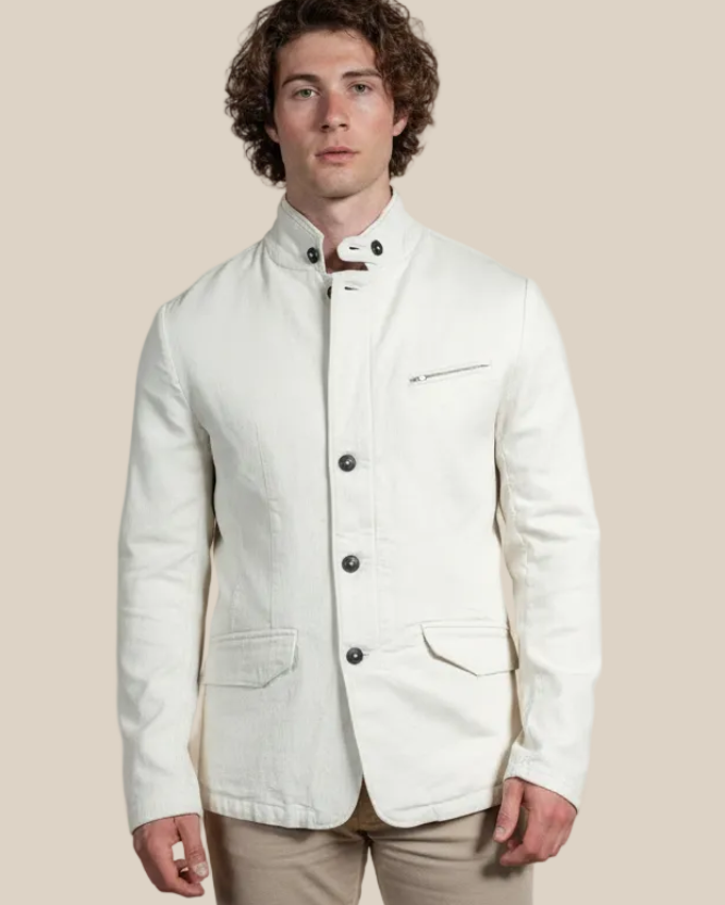 Man wearing a white jacket with black buttons against a beige background