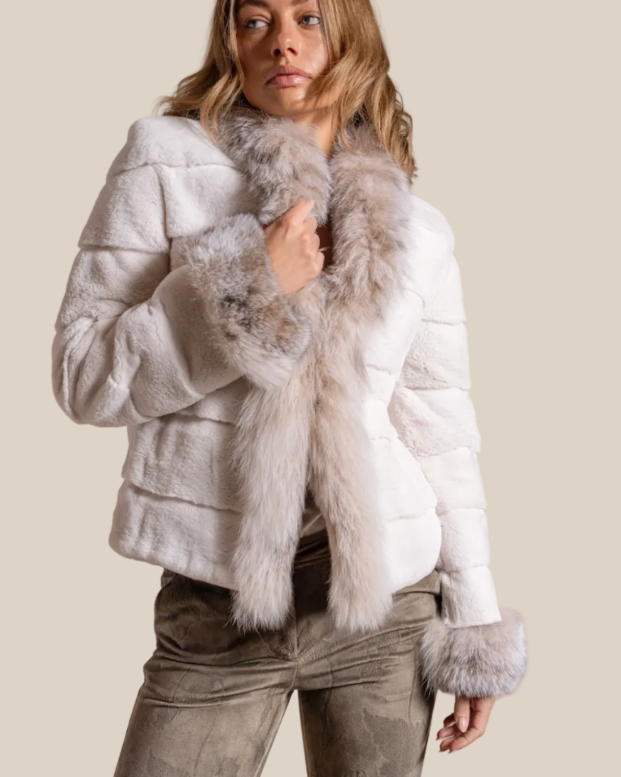 Woman wearing a white fur jacket with gray fur trim on a beige background
