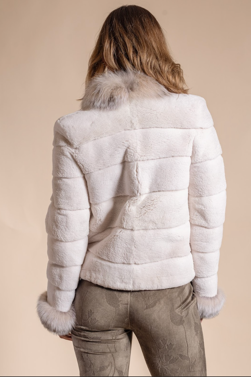 Person wearing a white fur jacket with a neutral background