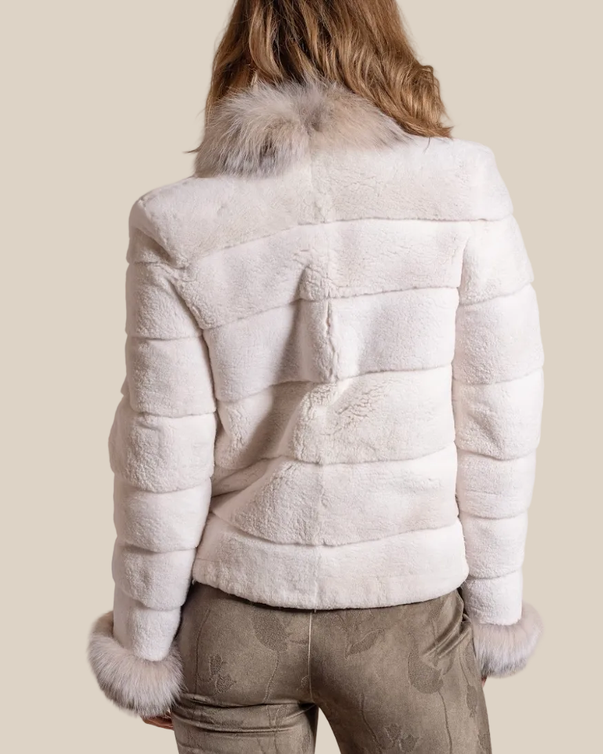 Person wearing a white fur jacket with a neutral background
