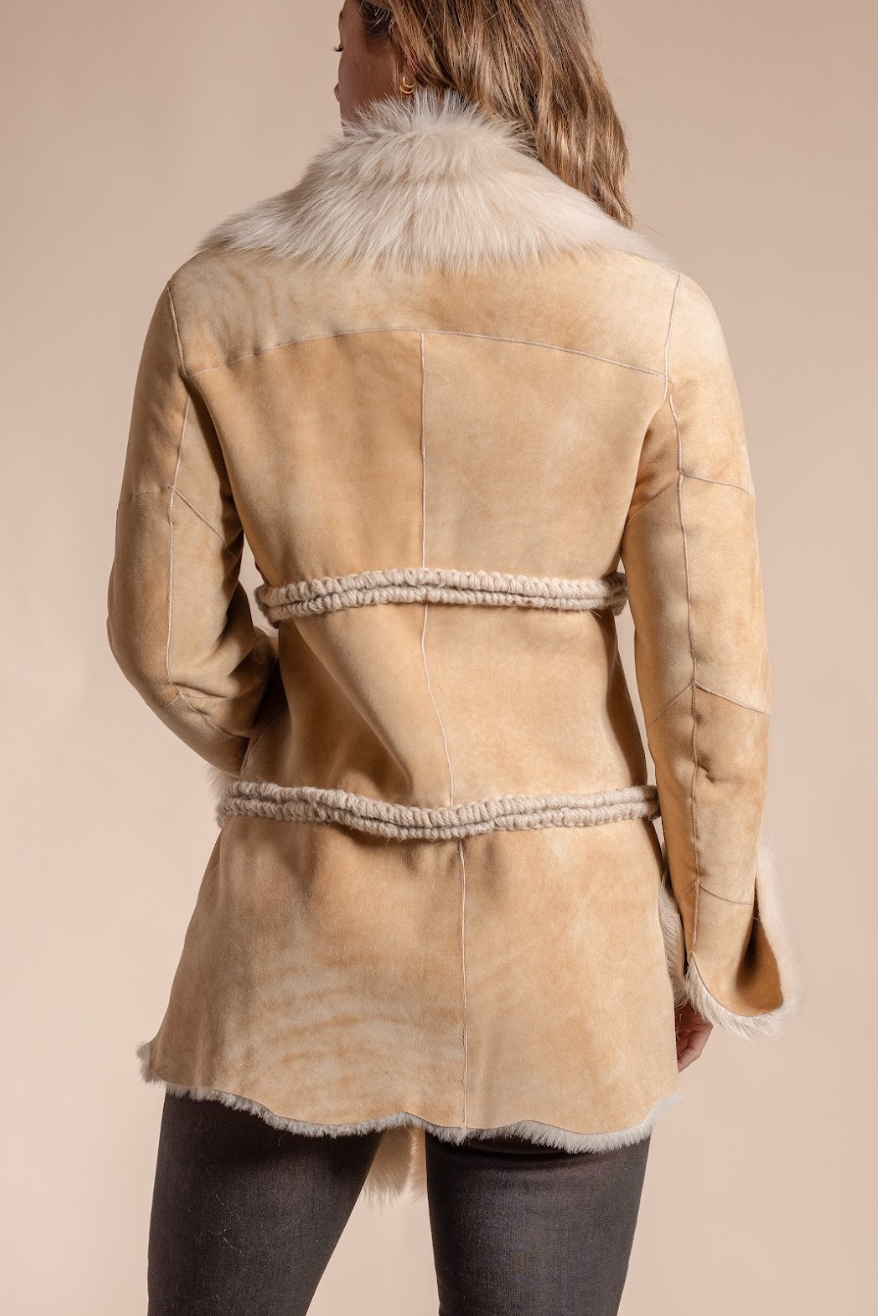 Beige shearling coat with fur collar on a beige background