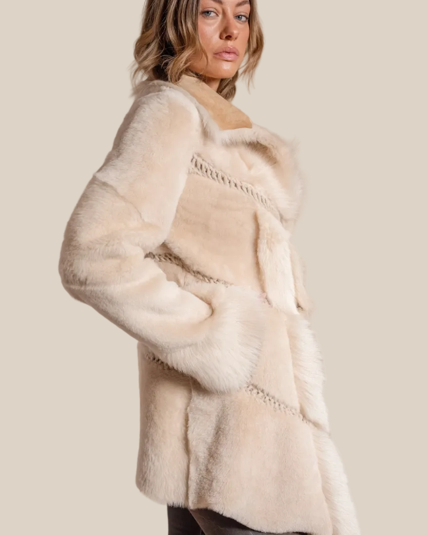 Woman wearing a cream fur coat against a beige background