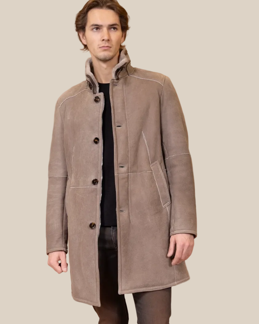 Man wearing a brown coat against a beige background
