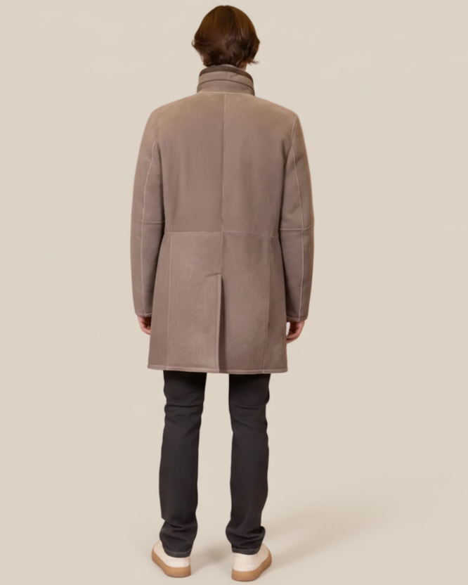 Person wearing a gray coat from behind on a beige background