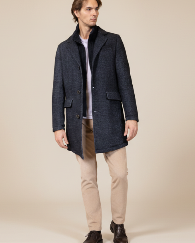 Man wearing a dark blue coat on a beige background