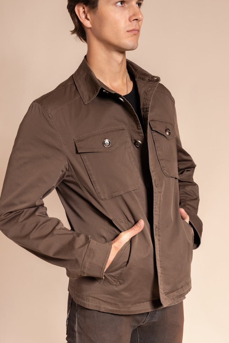 Man wearing a brown jacket on a beige background