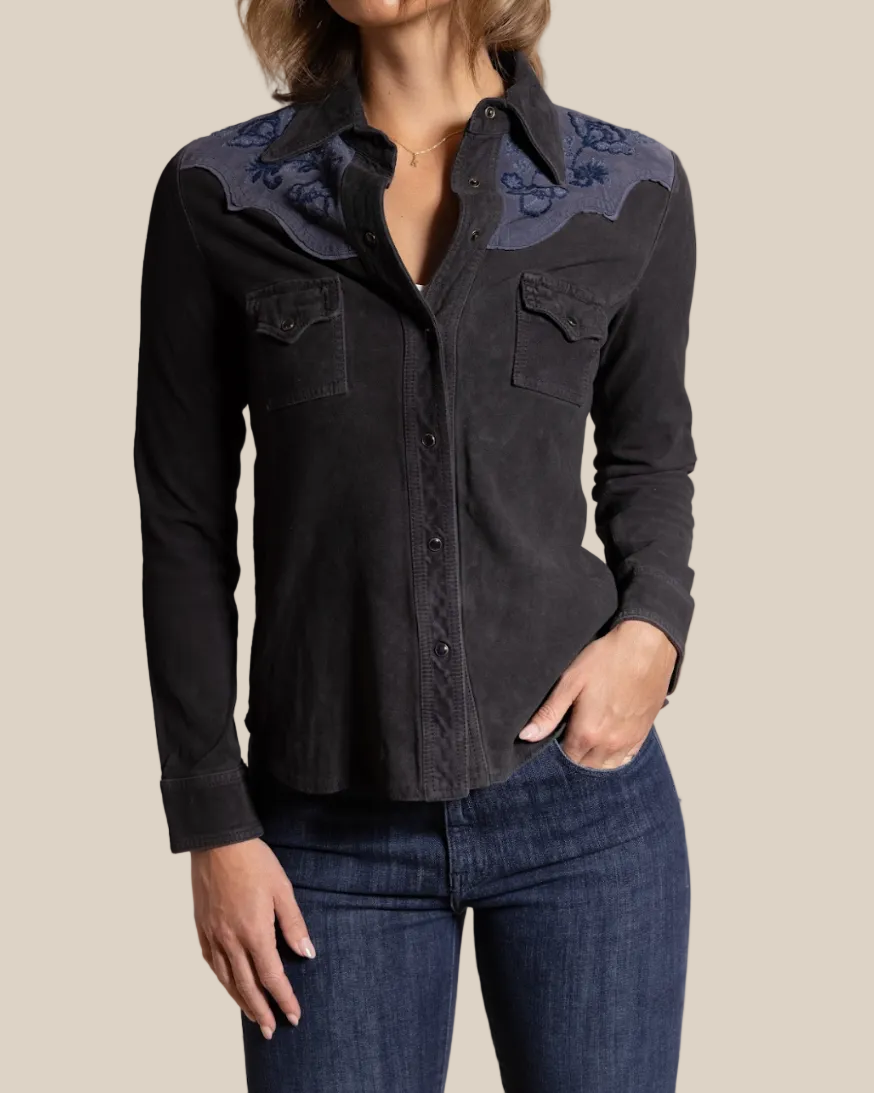 Black button-up shirt with floral embroidery on a beige background