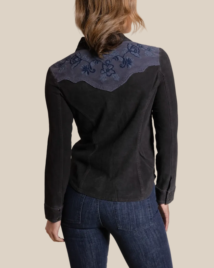 Black embroidered shirt worn by a person on a beige background