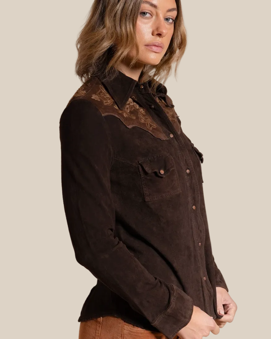 Woman wearing a brown jacket with intricate detailing on a beige background