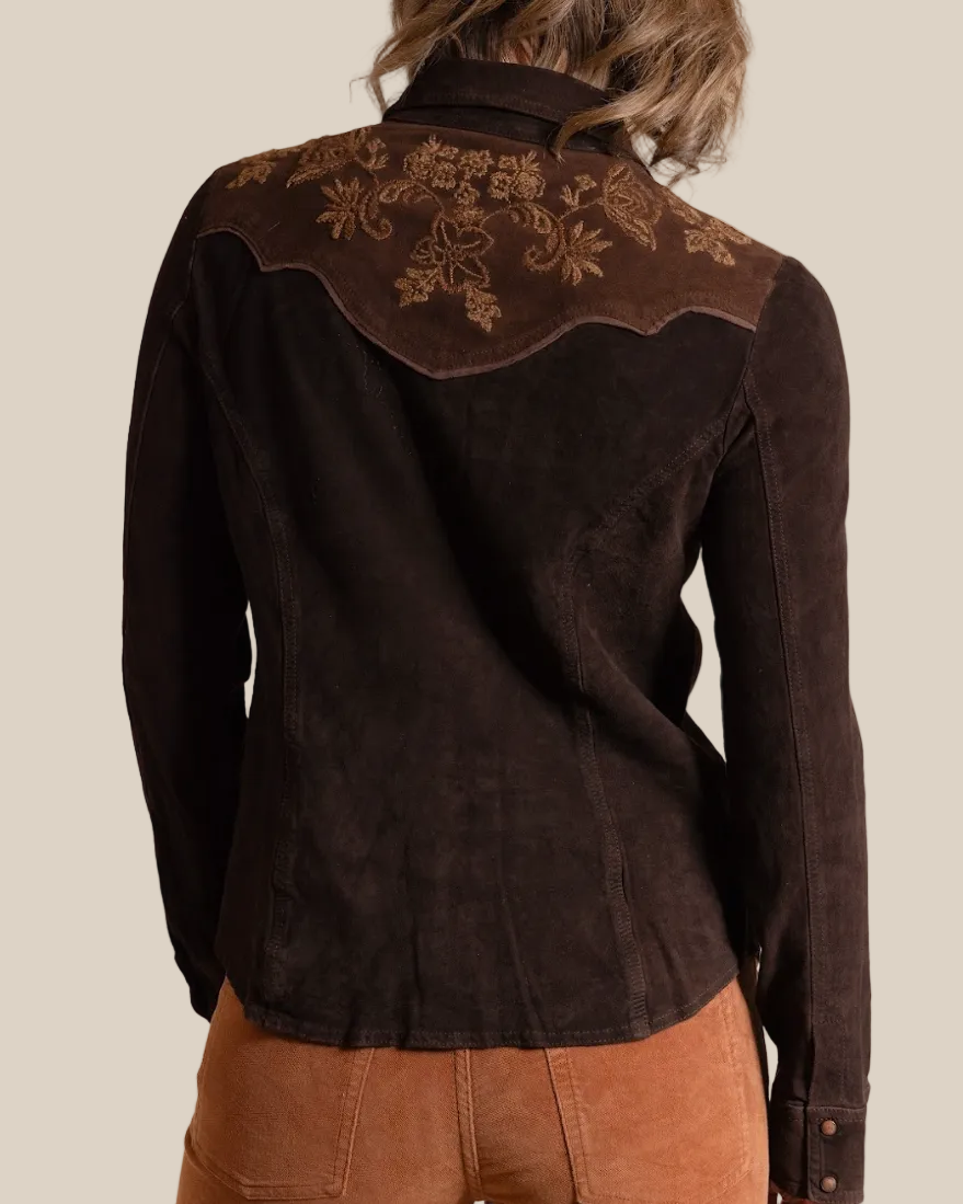 Brown embroidered blouse worn by a person on a beige background