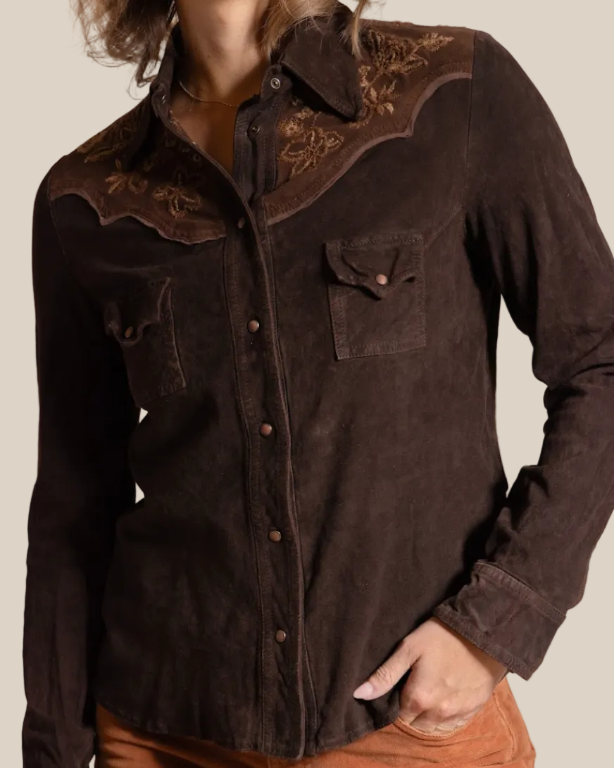 Brown button-up shirt with embroidered details worn by a person on a beige background