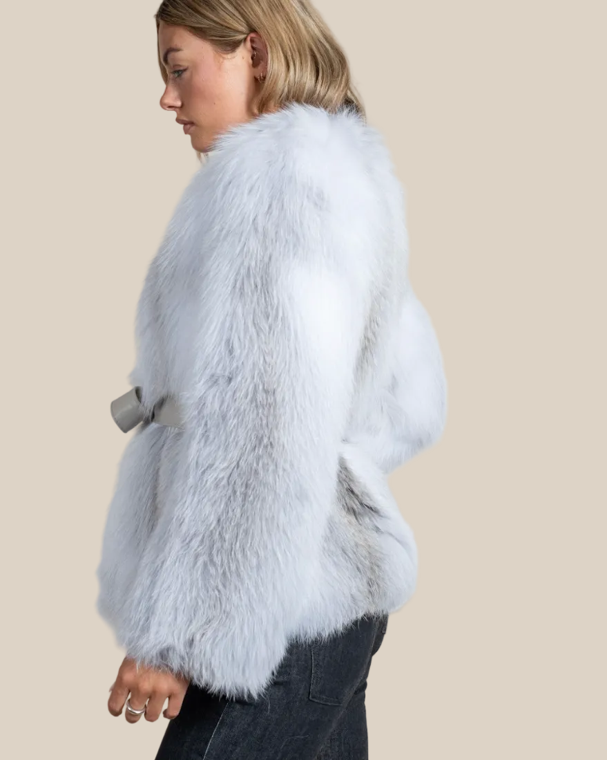 Light blue fur coat worn by a person on a beige background