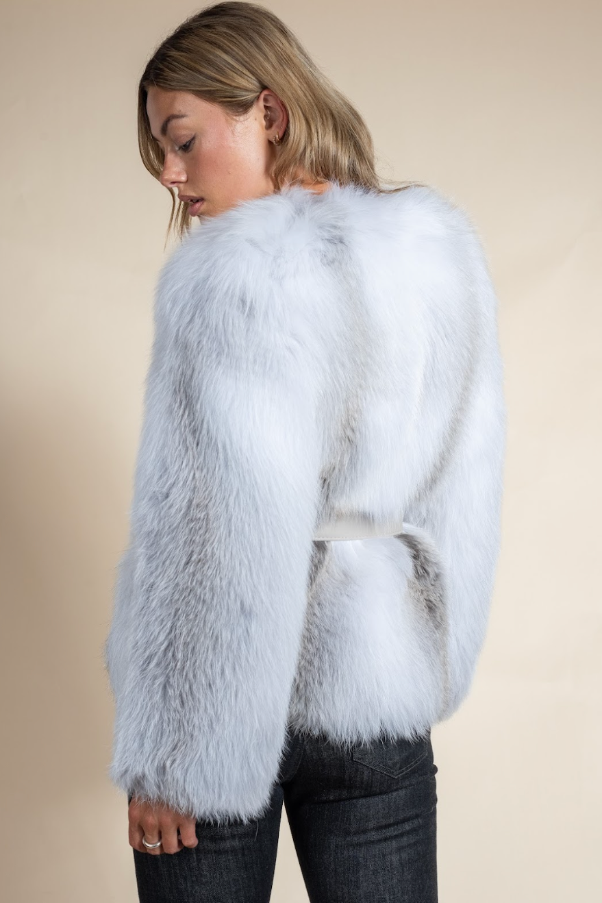 Woman wearing a fluffy white sweater against a beige background