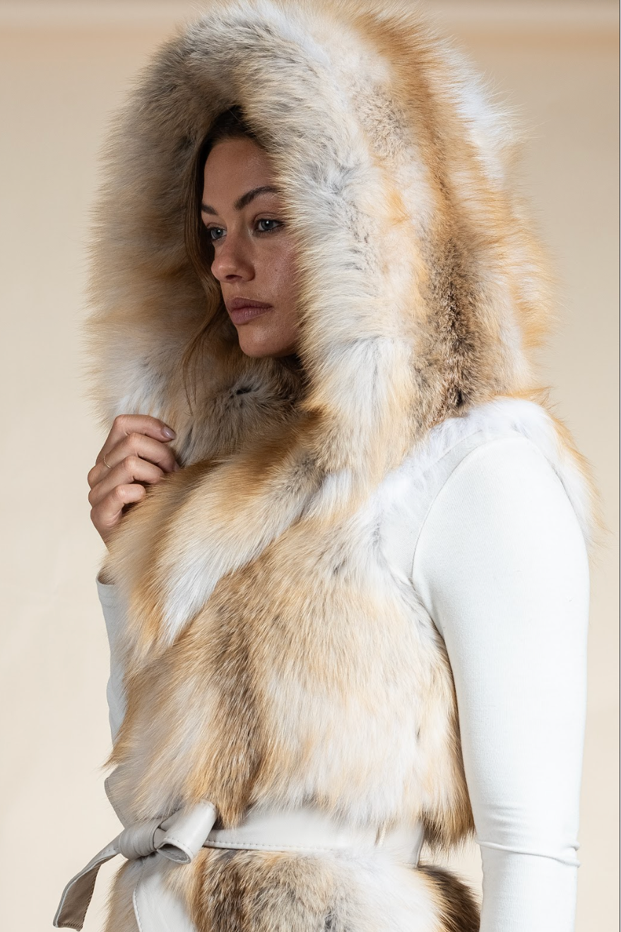 Person wearing a fur-lined hooded coat with a neutral background