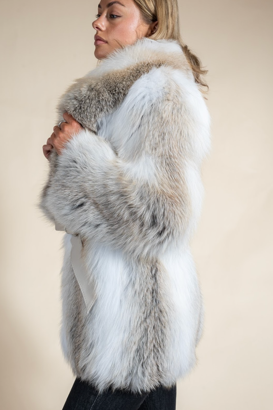 Woman wearing a fur vest with a neutral background