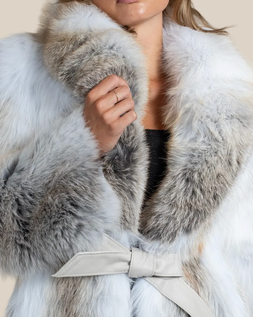 Close-up of a fur coat with a bow detail on a neutral background