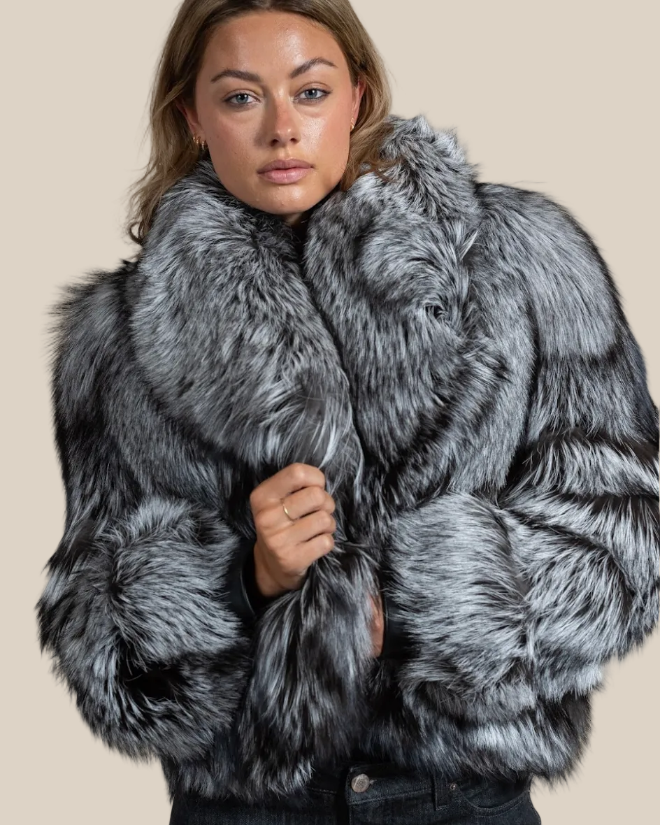 Woman wearing a gray fur coat against a beige background