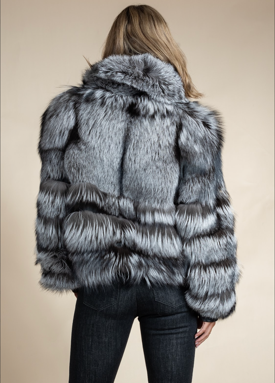 Person wearing a gray fur coat on a beige background